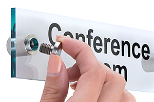 These pre-printed wall signs are available in the most common room designations used by almost every business or office. Closeup of a standoff being inserted into a wallmounted sign