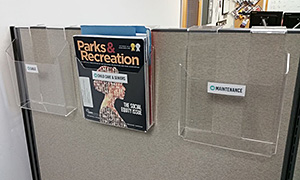 Three cubicle file hangers shown on a fabric partition wall