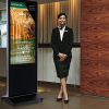 A hotel hostess standing next to a digital floor sign detailing a rewards club program