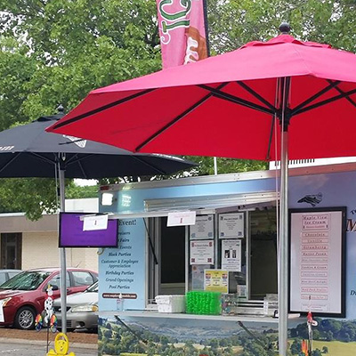 Food truck shown with large patio umbrellas