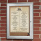 vertical outdoor corkboard protects posters from the weather. locks closed