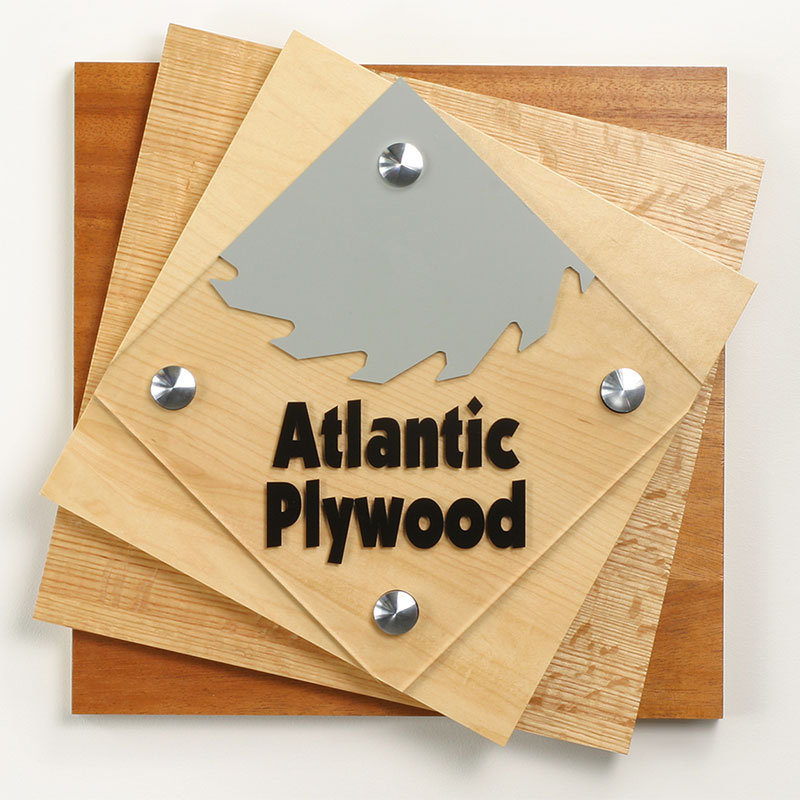 Standoffs supporting a stacked wood sign with company logo