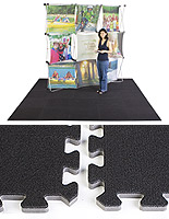 Closeup of two interlocking trade show carpet tiles in front of a full set shown with a backwall and woman on top of it