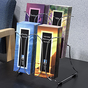 A wire countertop brochure holder on a table in a waiting area