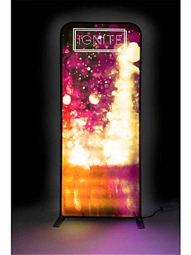 Backlit Ignite tension fabric banner stand in a dark room