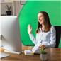 Woman sitting at desk with green screen background