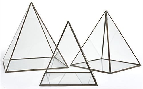 Medium glass pyramid display case with gold metal pipping along edges 