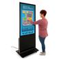 Woman interacting with 55" digital poster stand in black with touch screen