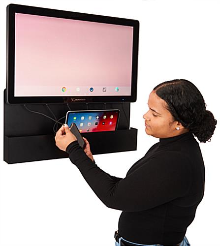 Woman plugging device into hanging digital charging kiosk