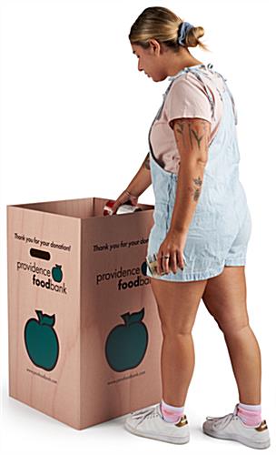 Disposable cardboard trash bin has side handles 