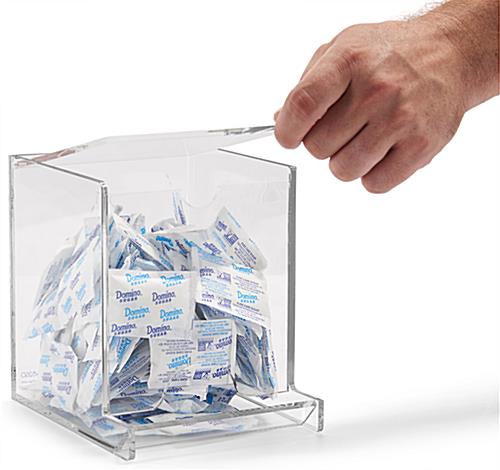 Single use packet dispenser with an easy to open lid 