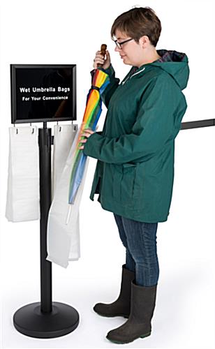 Gray belt stanchion umbrella station with courtesy bags for patrons