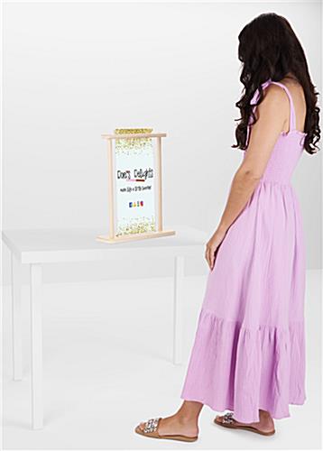 Woman standing next to small wood tabletop banner stand