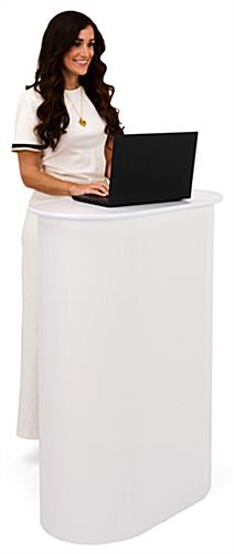 Woman with laptop standing behind the white podium