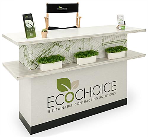 Custom Eco-Friendly Trade Show Counter with plants, sign holder, and a chair behind it