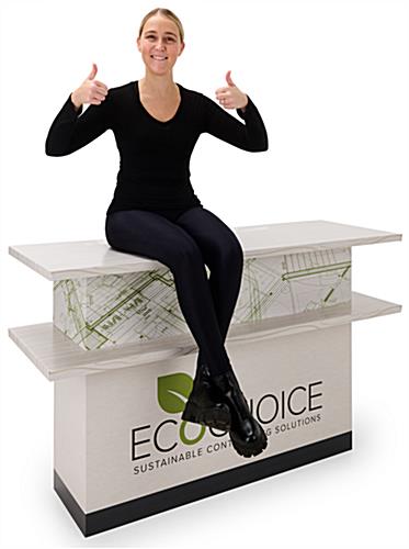 Woman sitting on top of sturdy recyclable trade show counter