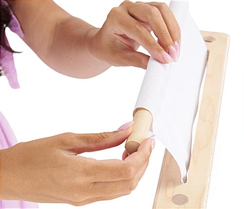 Inserting dowel into top of custom graphic that sits in wooden tabletop banner base