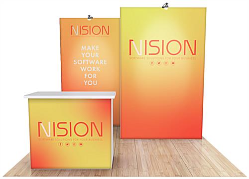 1007 Gravitee™ Trade Show Booth Rental with two perpendicular backwalls - one set in front of the other - with two LED stem lights above and podium with white countertop seen from the front